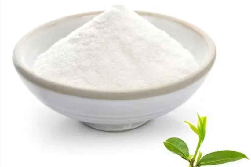 L-theanine powder in a bowl with green tea leaves